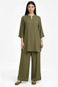 A woman modeling a matching olive green two-piece lounge set consisting of a short-sleeve tunic top with a split neckline and wide-leg pants, photographed against a plain white studio background.