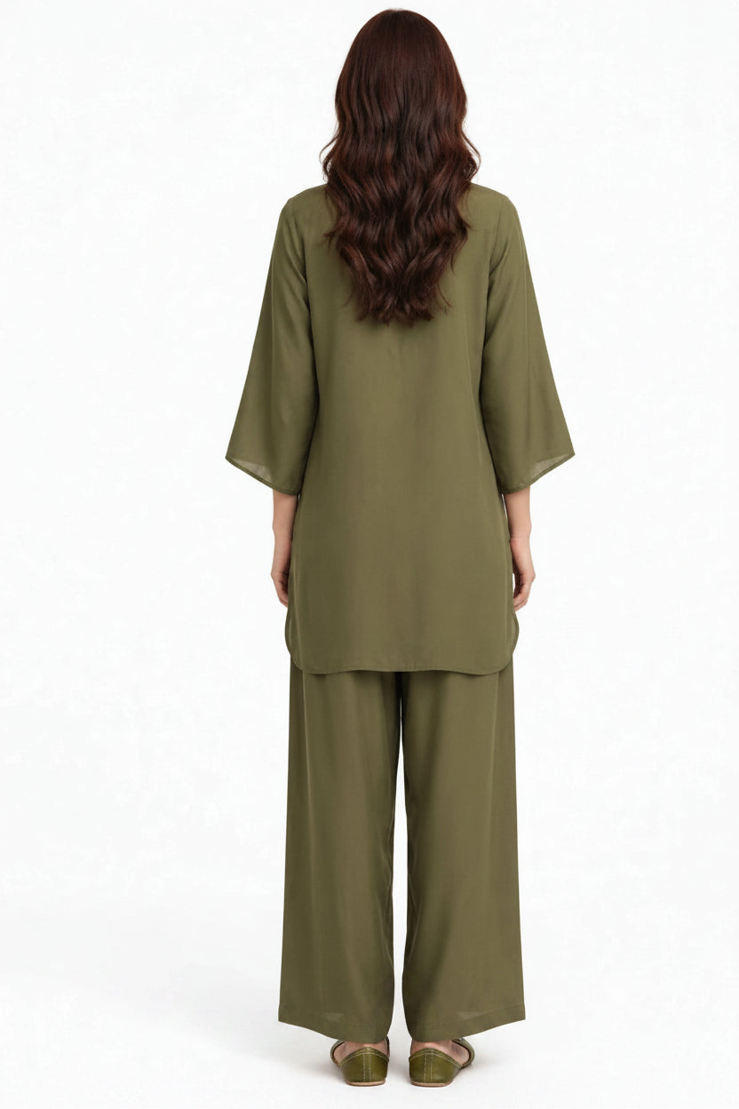 A woman viewed from the back wearing an olive green two-piece outfit consisting of a loose short-sleeve top and matching wide-leg pants, against a plain white background.