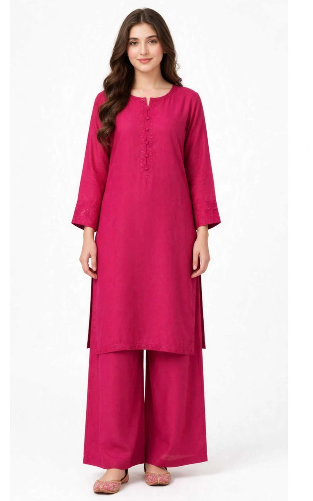 A woman modeling a bright magenta pink kurta set with matching wide-leg pants, featuring a three-quarter sleeve design and a buttoned neckline, set against a plain white background.