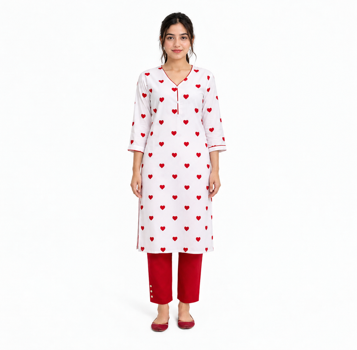 A woman modeling a white three-quarter sleeve kurta with a red heart pattern, paired with red pants and red shoes, against a plain white background.